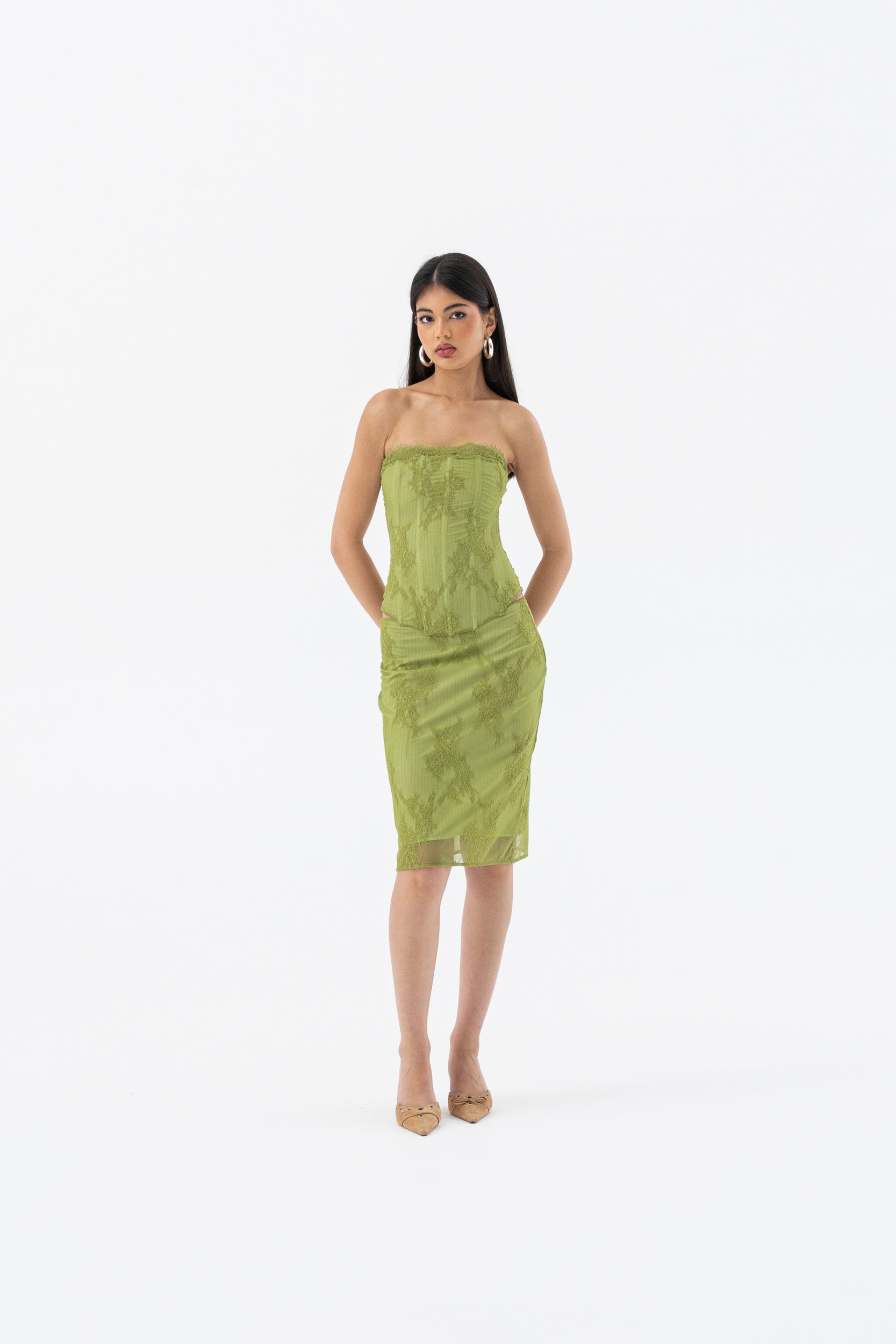 Woman wearing a green strapless dress on a white background